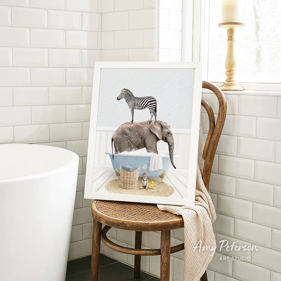 A framed image of a zebra standing on an elephant's back, both in a bathtub, is displayed on a wooden chair in a bathroom setting.