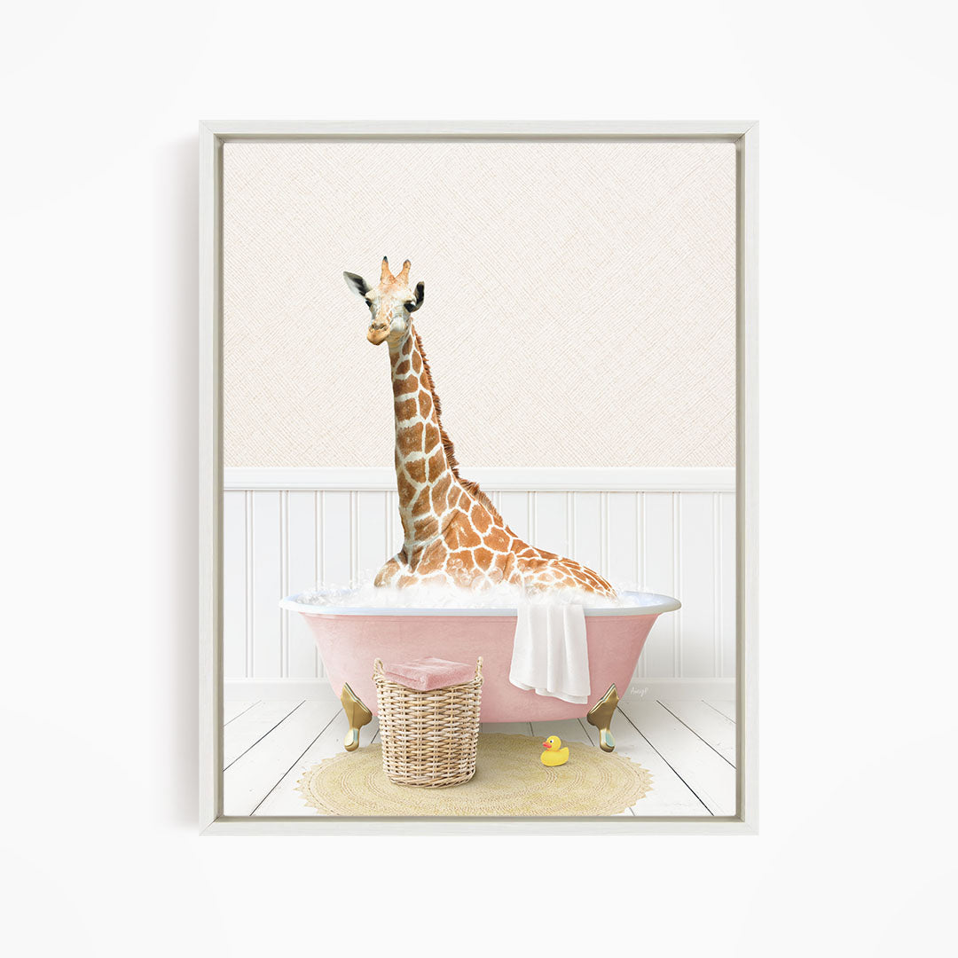 A giraffe sitting in a pink bathtub, surrounded by a yellow rubber duck and a basket.