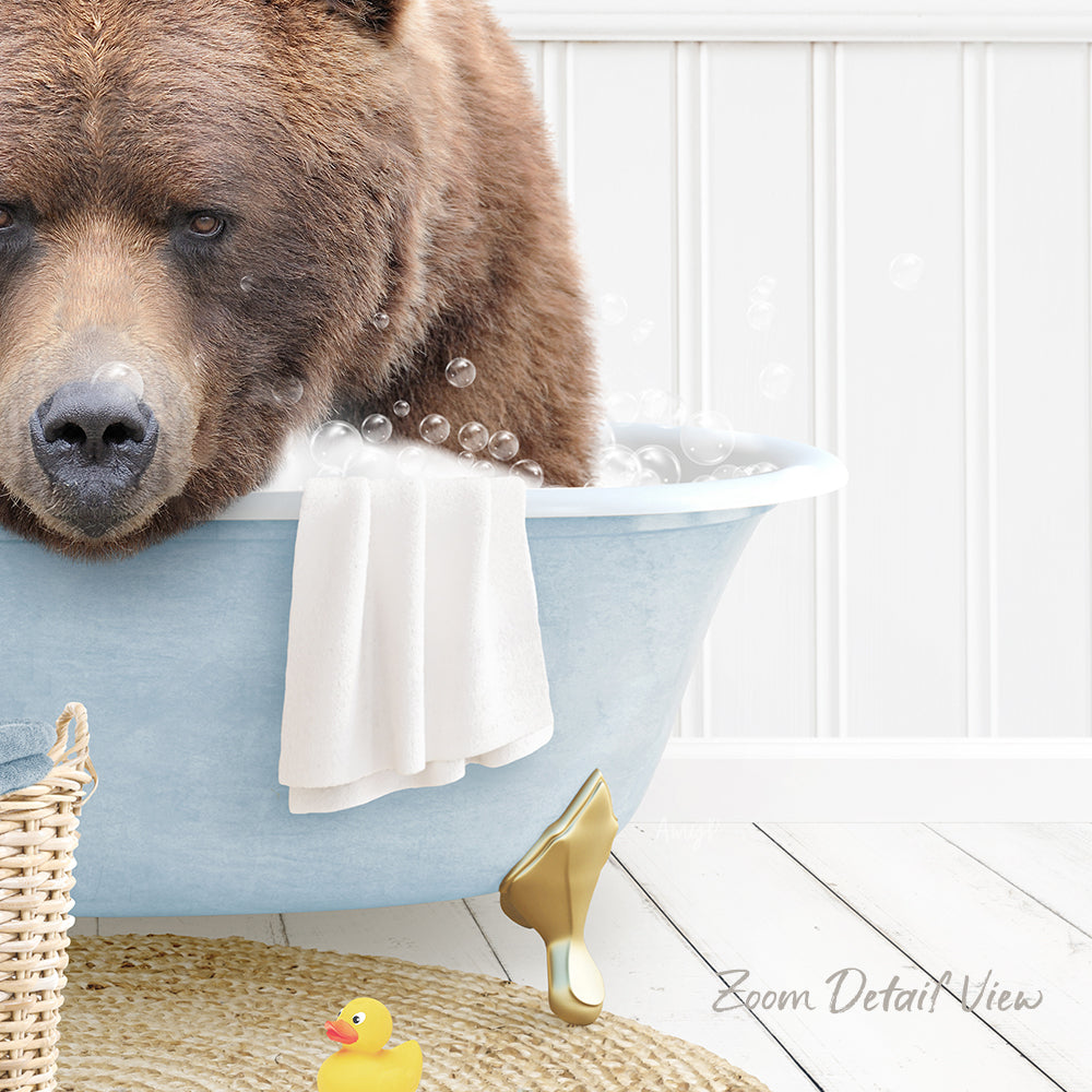 A large brown bear is sitting in a blue bathtub filled with bubbles, surrounded by a yellow rubber duck and a white towel.