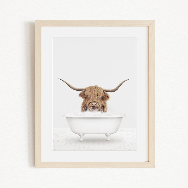 A Highland cow with long horns is sitting in a white bathtub filled with water, creating a whimsical and playful scene.