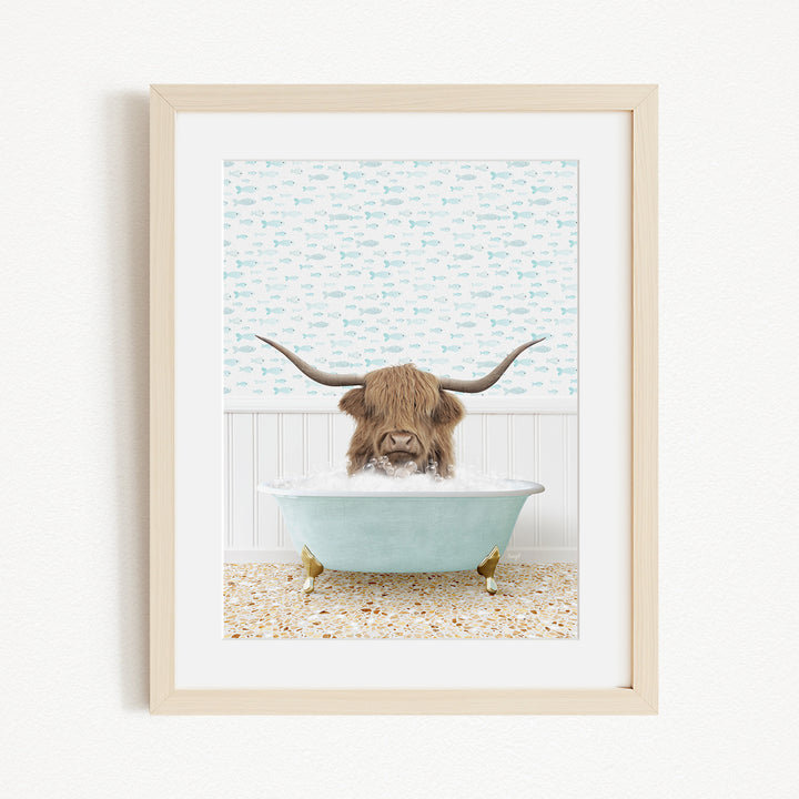 A brown cow with long horns is sitting in a light blue bathtub, surrounded by a patterned wall and a beige floor.