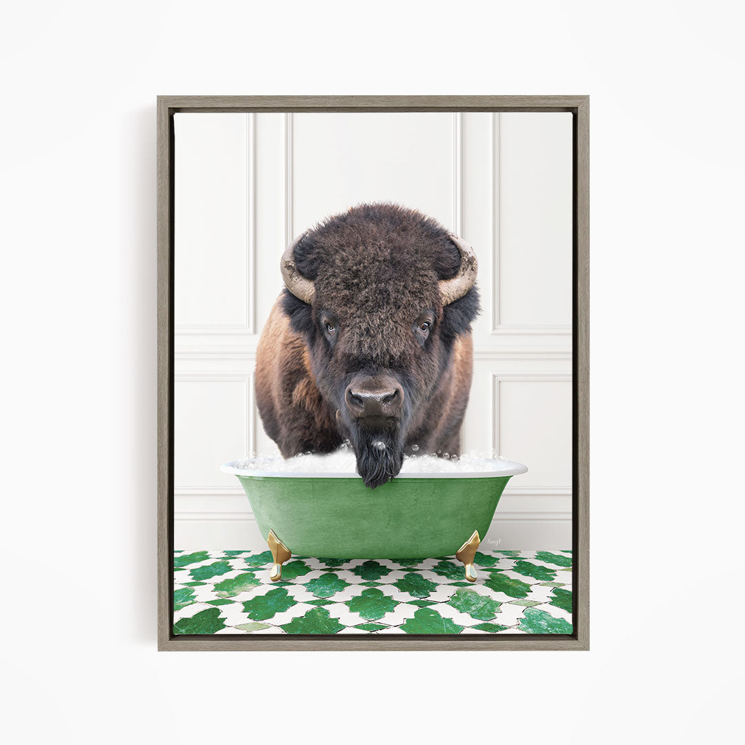 A buffalo with a long, shaggy mane is standing in a green bathtub filled with water, with its head submerged and looking directly at the camera.