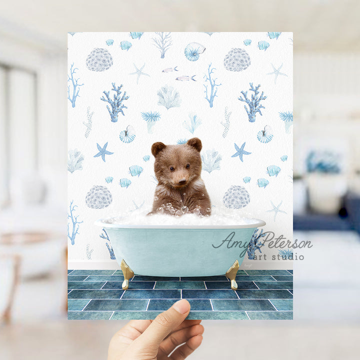 a hand holding up a photo of a teddy bear in a bathtub