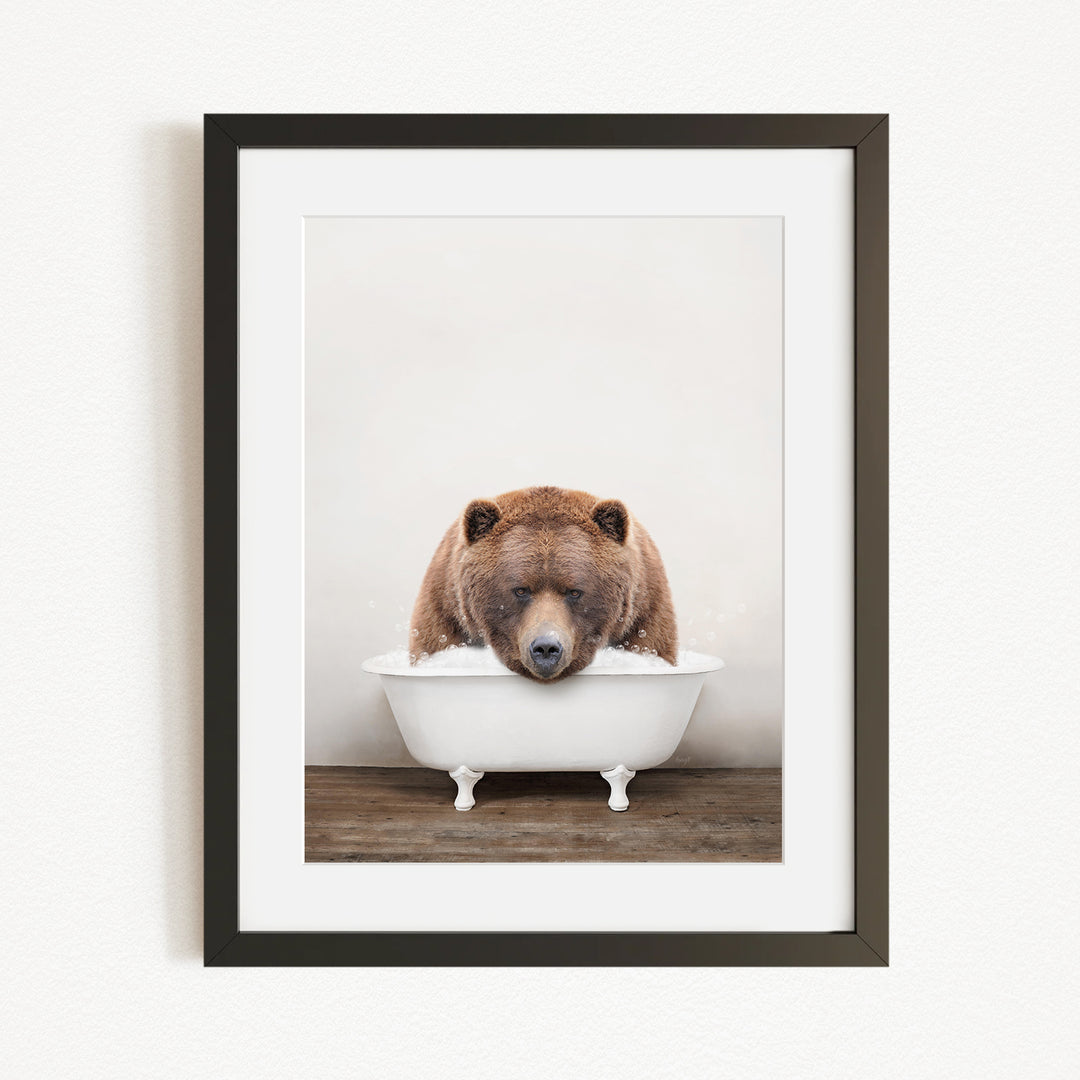 A brown bear is sitting in a white bathtub, appearing to be enjoying a relaxing bath.