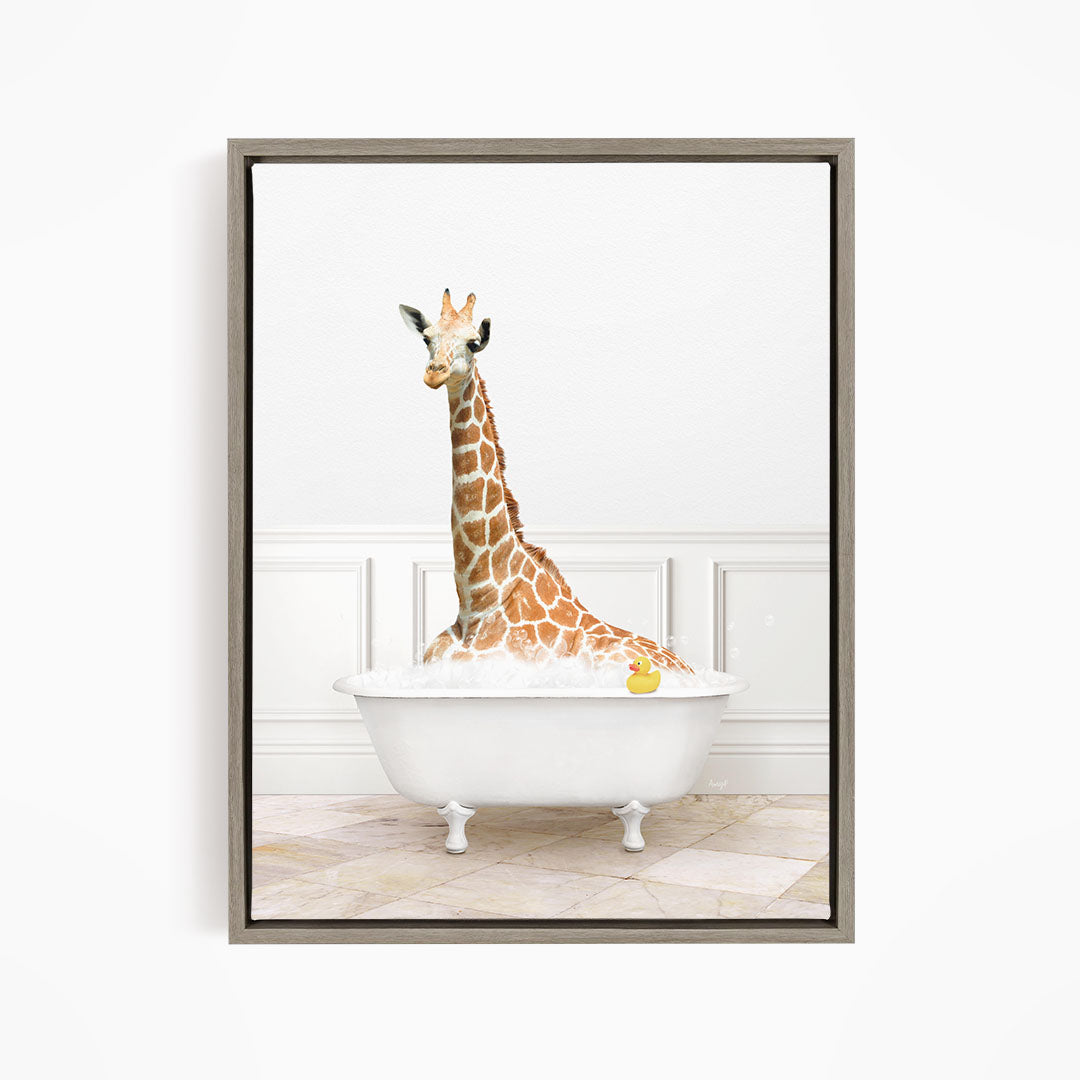 A giraffe is sitting in a white bathtub filled with water, with a yellow rubber duck floating in the tub.