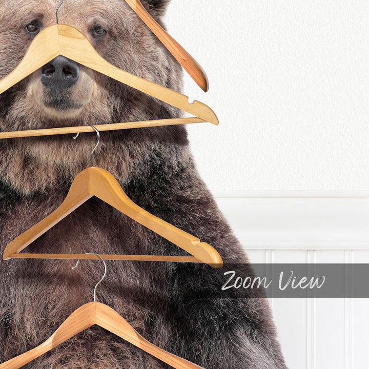 A close-up of a large brown bear with multiple wooden hangers attached to its head and neck, creating a unique and whimsical scene.