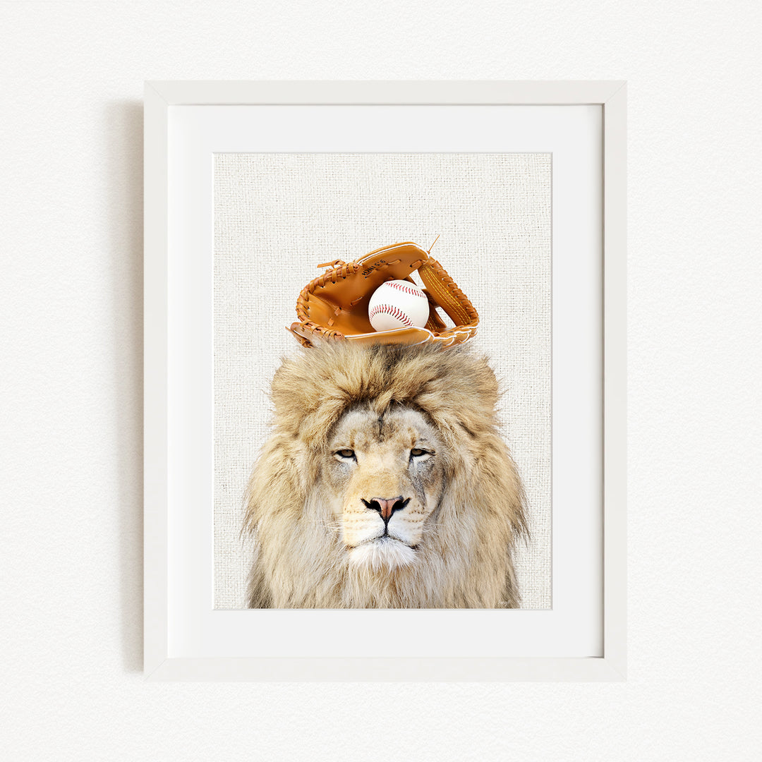 A framed image of a lion wearing a baseball glove on its head.