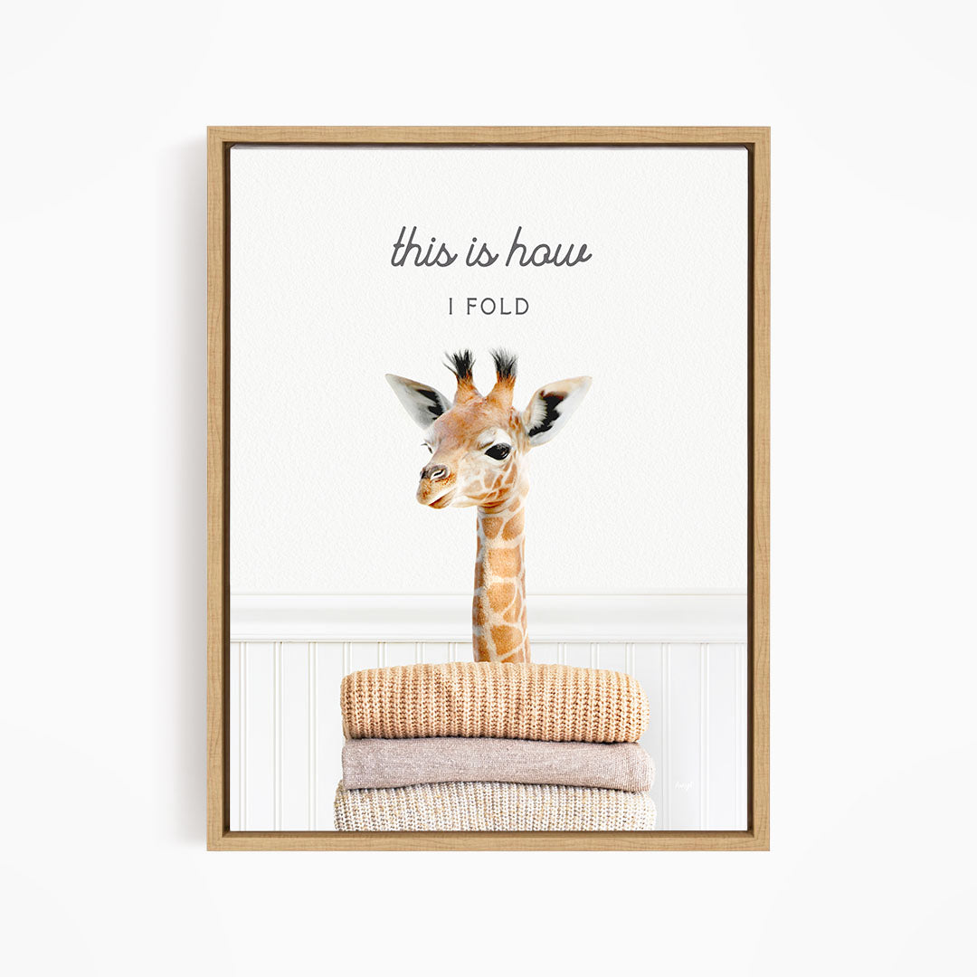 A giraffe standing on a stack of folded blankets, with the text "this is how I fold" written above the image.