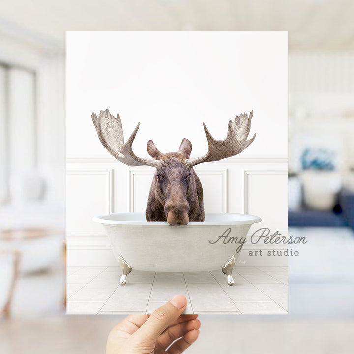 a person holding up a card with a picture of a moose in a bathtub