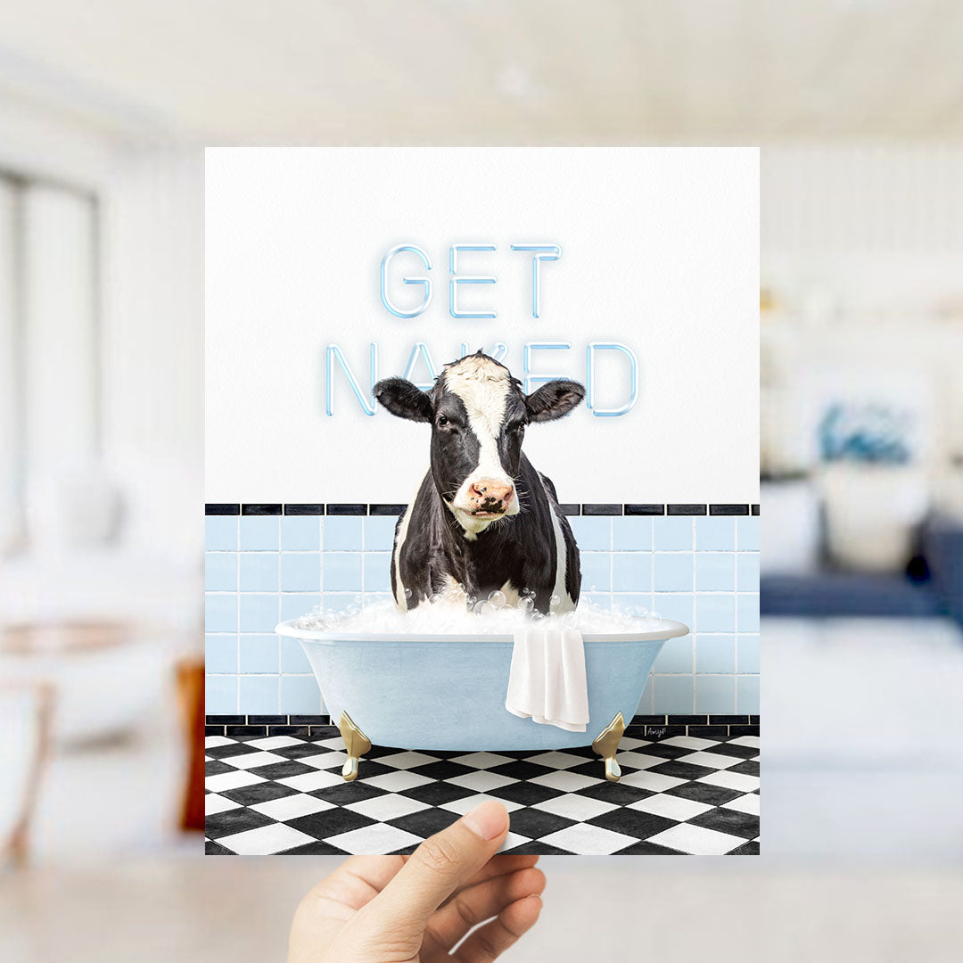 A cow sitting in a bathtub filled with bubbles, with the words "GET NAKED" written on the wall behind it.