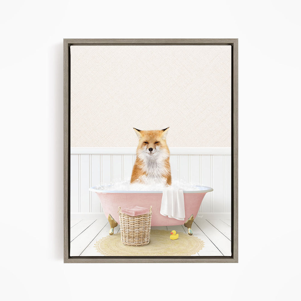 A red fox is sitting in a pink bathtub filled with bubbles, surrounded by a yellow rubber duck and a white towel.