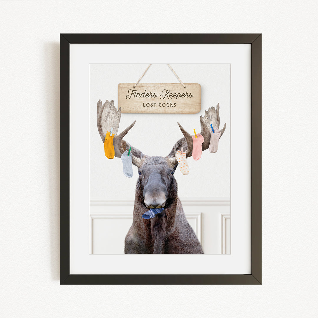 A framed image of a moose with a sign that says "Finders Keepers Lost Socks" hanging above it.