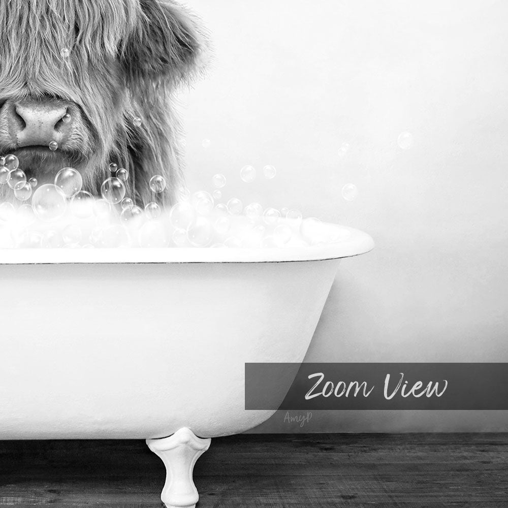 A close-up black and white image of a cow's head partially submerged in a bathtub filled with bubbles.