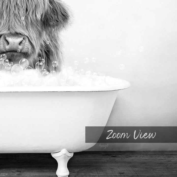 A close-up black and white image of a cow's head partially submerged in a bathtub filled with bubbles.