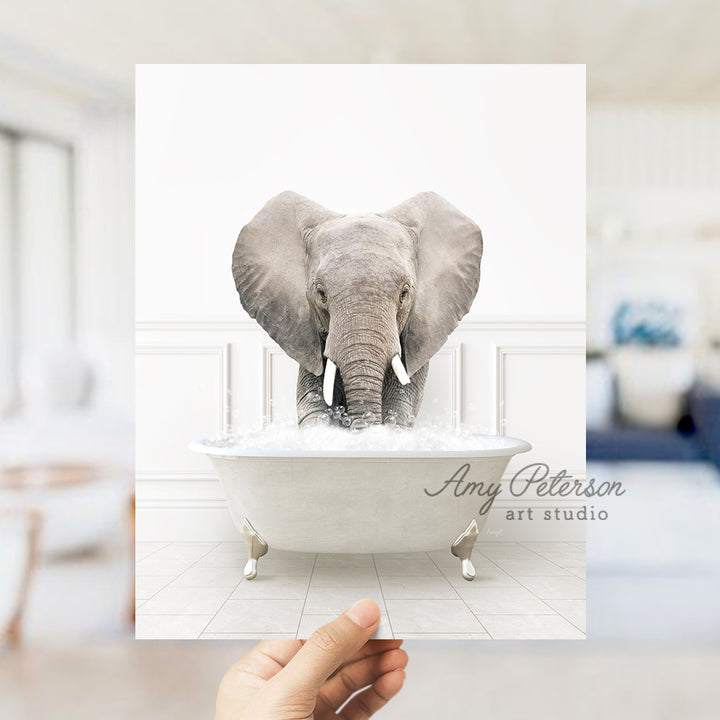 a person holding up a picture of an elephant in a bathtub