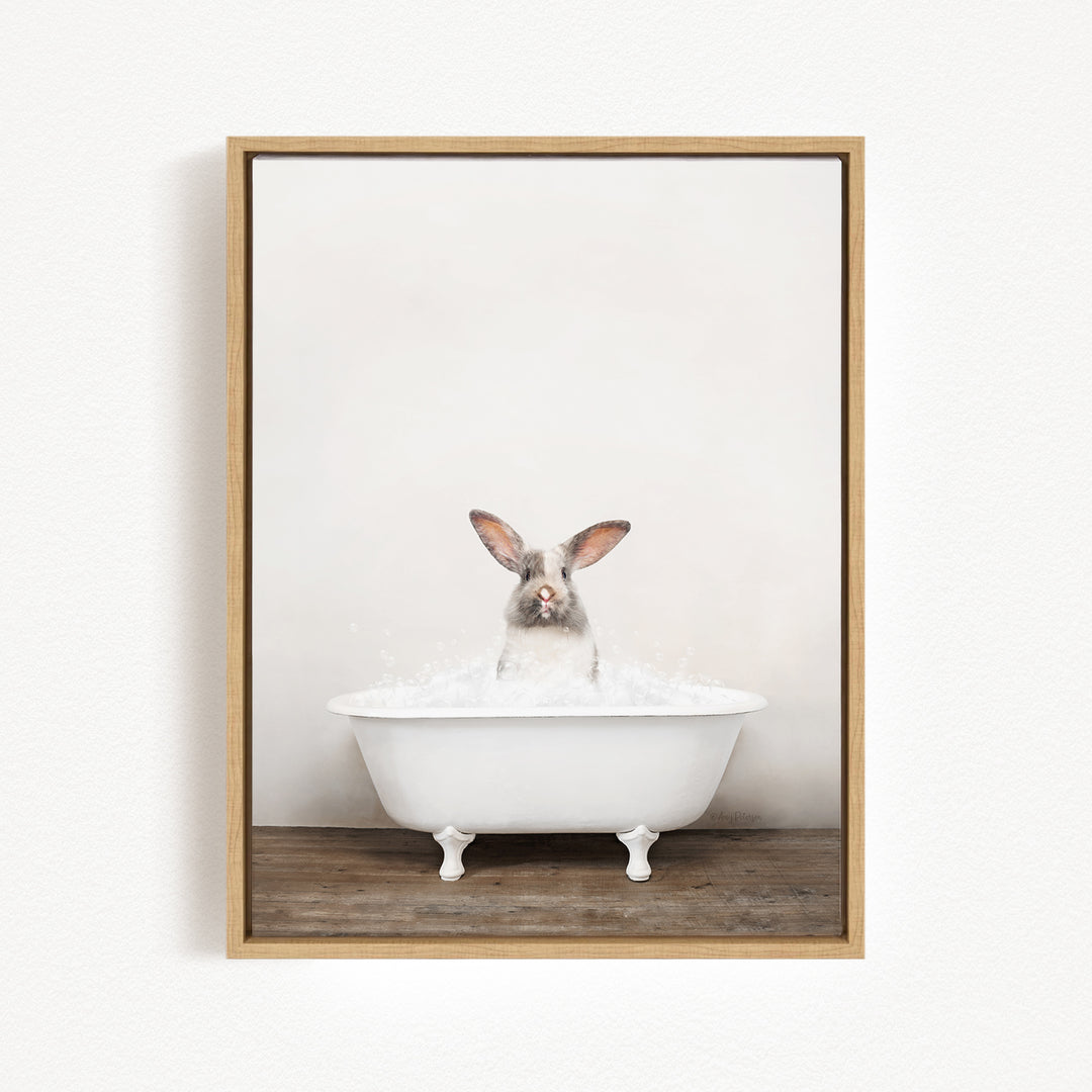 A white rabbit sitting in a white bathtub filled with water, looking directly at the camera.