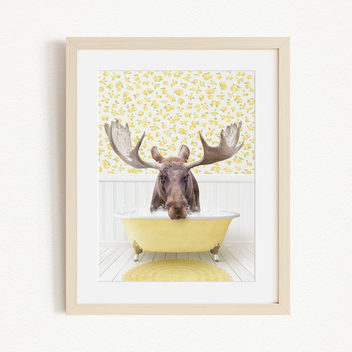A moose with large antlers is sitting in a yellow bathtub, surrounded by a yellow floral pattern on the wall behind it.