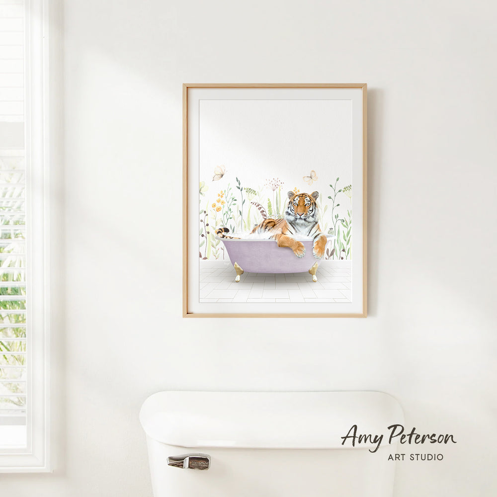 A framed illustration of a tiger sitting in a bathtub, surrounded by flowers and plants, is hanging on a white wall.