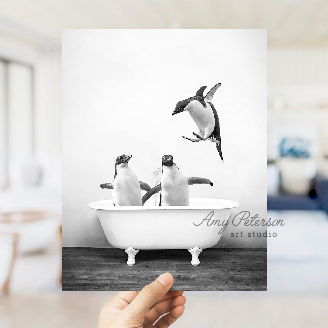 a hand holding up a card with penguins in a bathtub