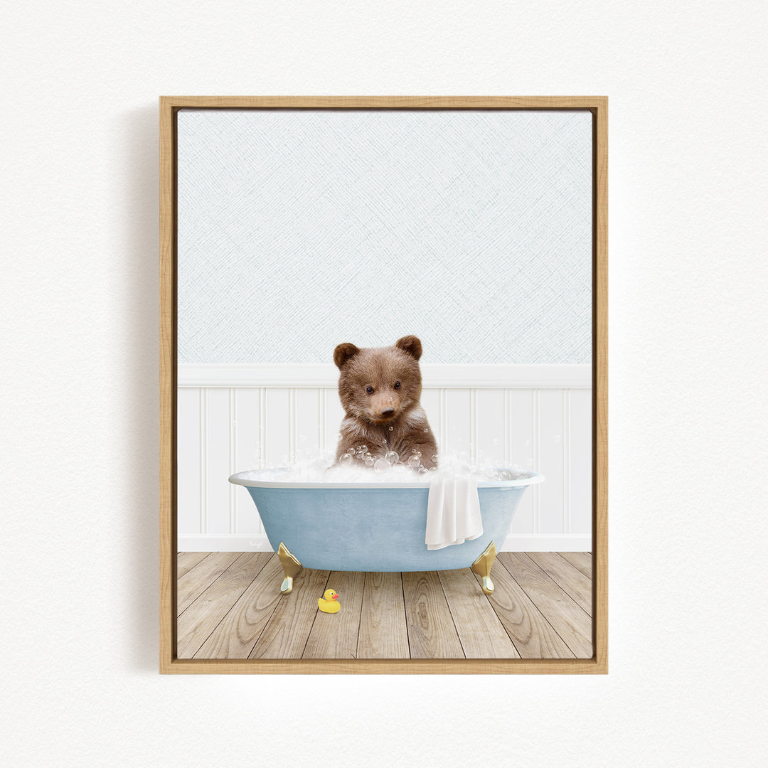 A brown bear sitting in a blue bathtub filled with water, surrounded by a white towel and a yellow rubber duck.