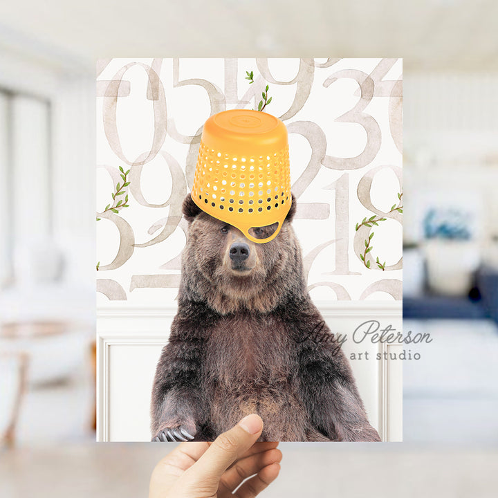 a person holding a card with a picture of a bear wearing a yellow hat