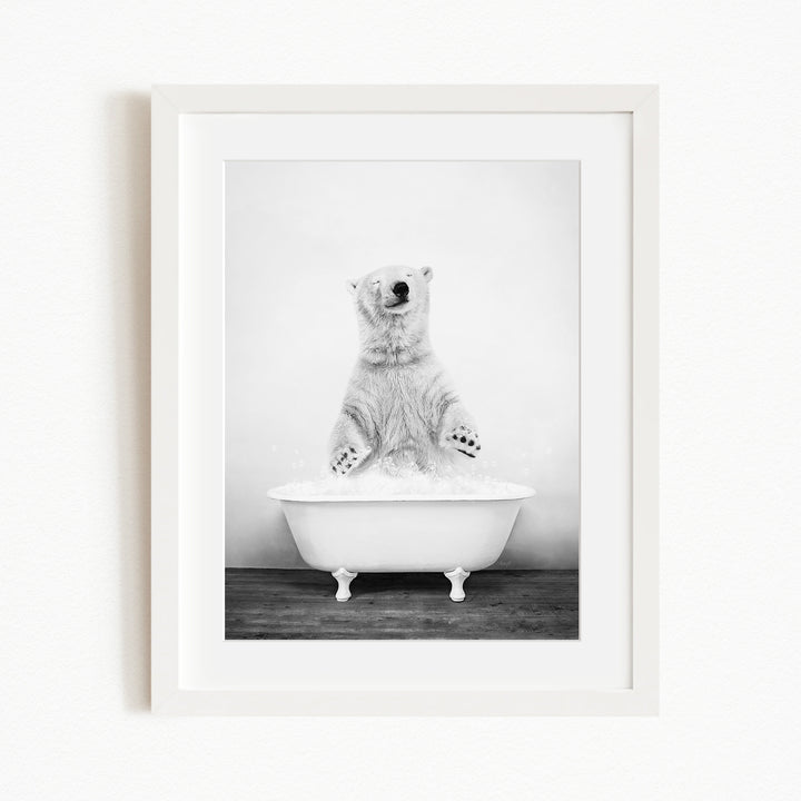 A polar bear standing in a white bathtub filled with water, appearing to be enjoying a bath.