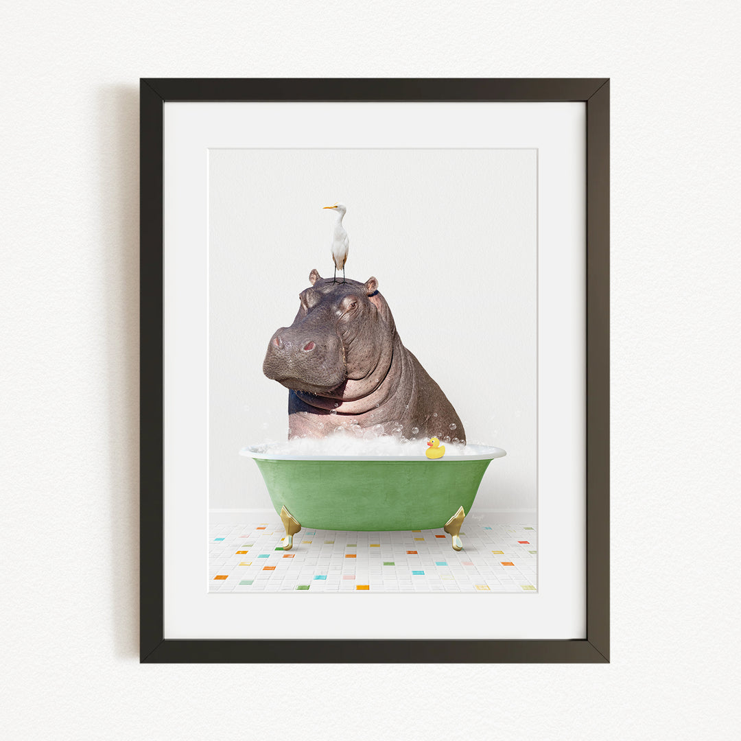 A framed image depicting a hippopotamus sitting in a green bathtub, with a bird perched on its head.