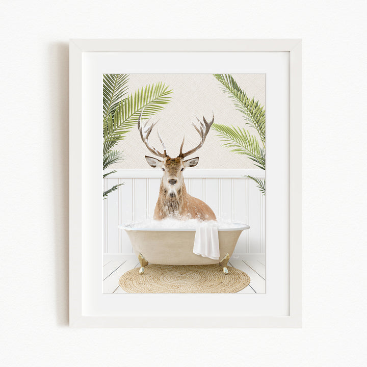 A deer with antlers is sitting in a bathtub filled with bubbles, surrounded by green palm fronds.