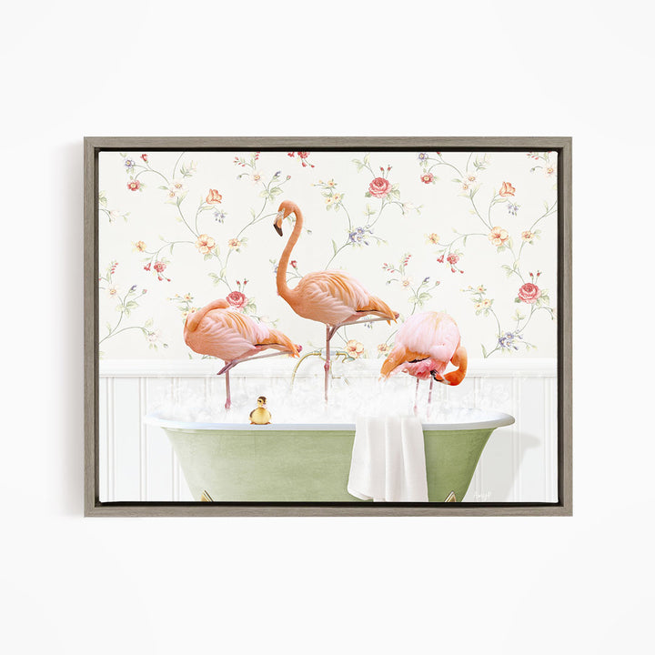 A framed image depicting three pink flamingos standing in a green bathtub filled with water, surrounded by a floral wallpaper.