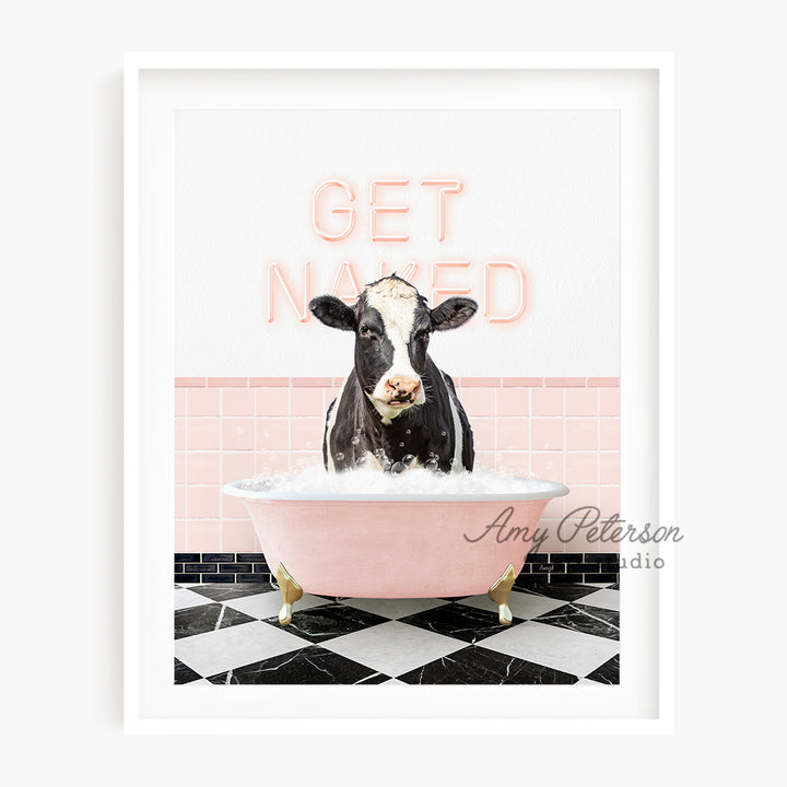 a black and white cow sitting in a pink bath tub