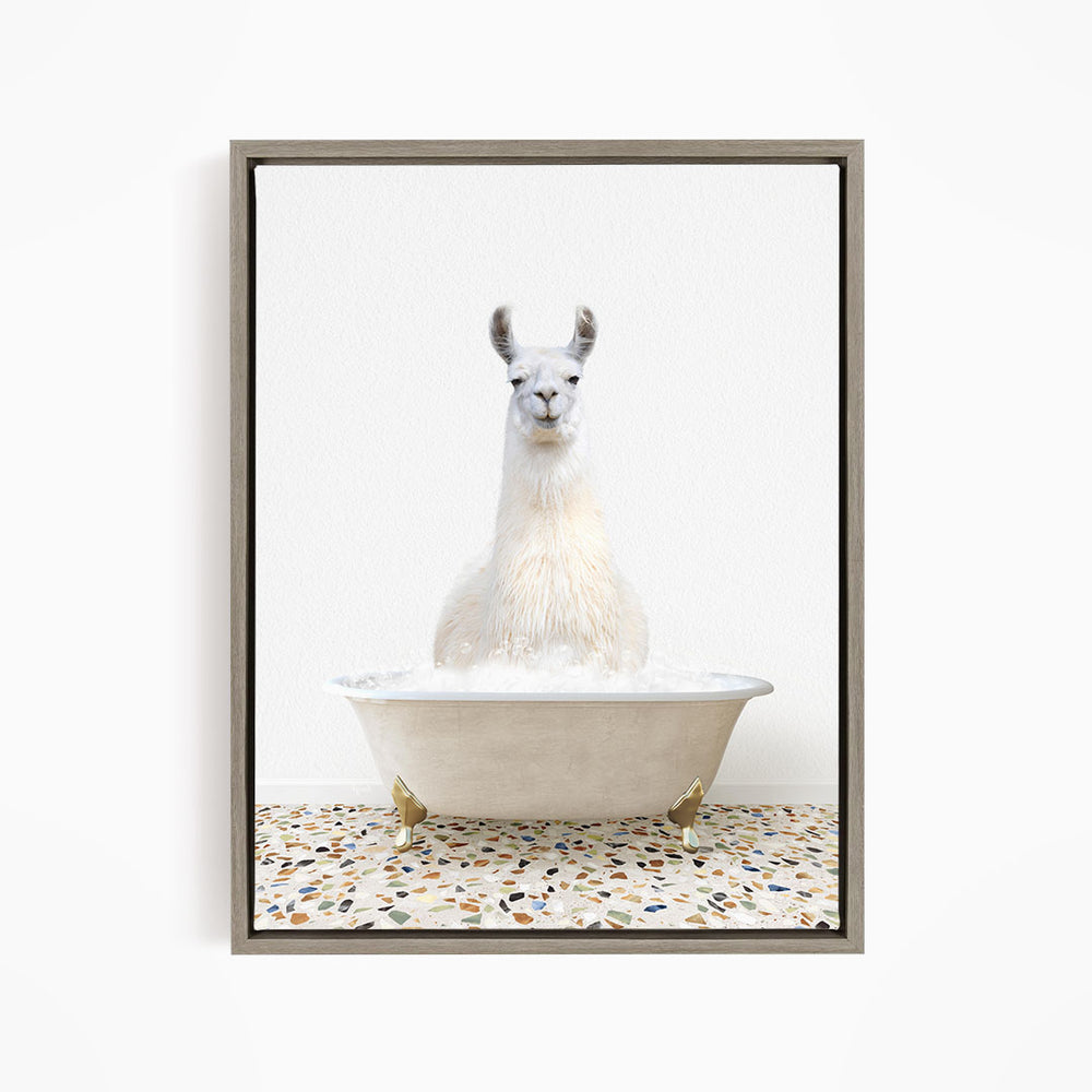 A white llama sitting in a white bathtub filled with water, with a speckled floor in the background.