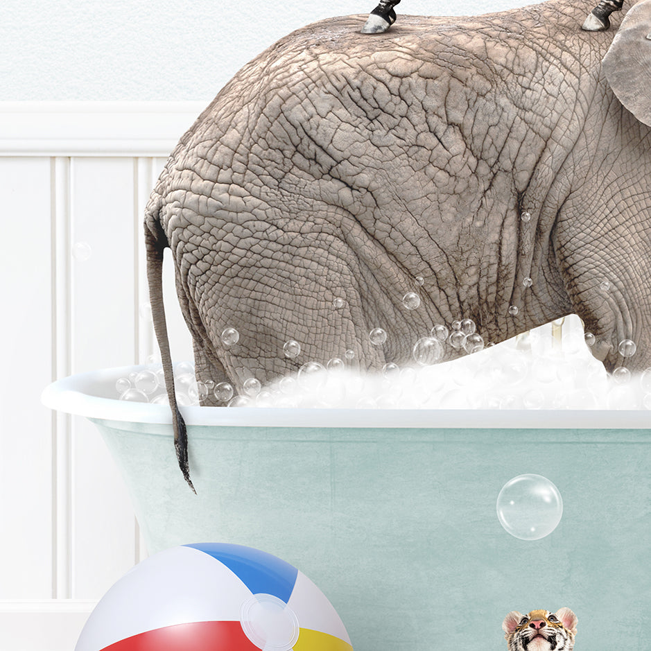 an elephant in a bathtub with bubbles and a beach ball