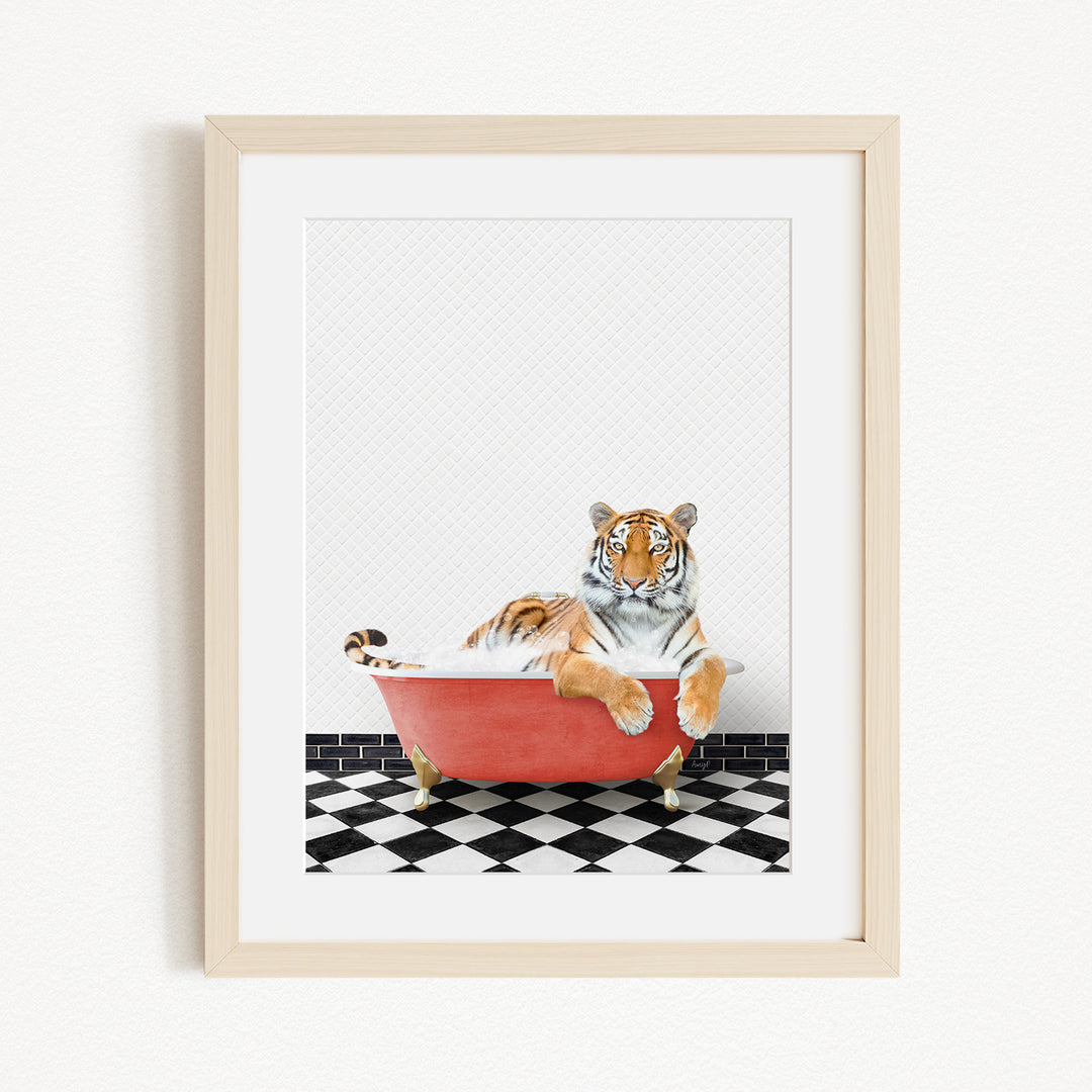 A tiger is sitting in a red bathtub on a black and white checkered floor.