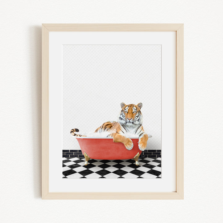 A tiger is sitting in a red bathtub on a black and white checkered floor.