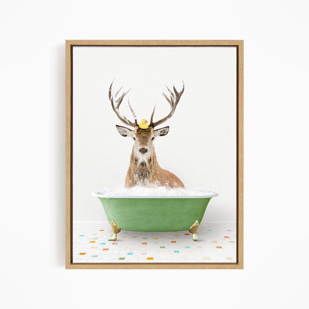 A deer with antlers is sitting in a green bathtub filled with bubbles, with a yellow rubber duck perched on its head.