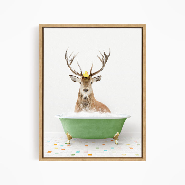 A deer with antlers is sitting in a green bathtub filled with bubbles, with a yellow rubber duck perched on its head.