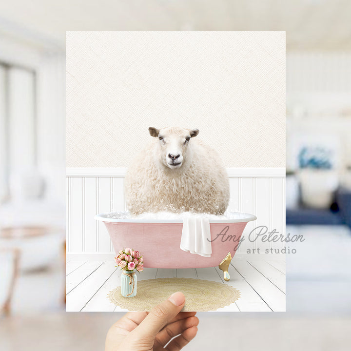 a hand holding a card with a sheep in a bathtub