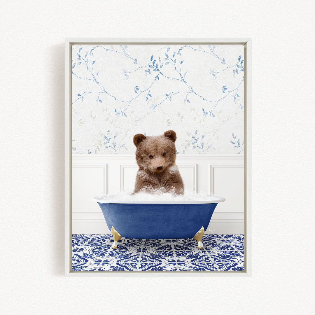 A brown bear sitting in a blue bathtub filled with bubbles, surrounded by a blue and white patterned rug.