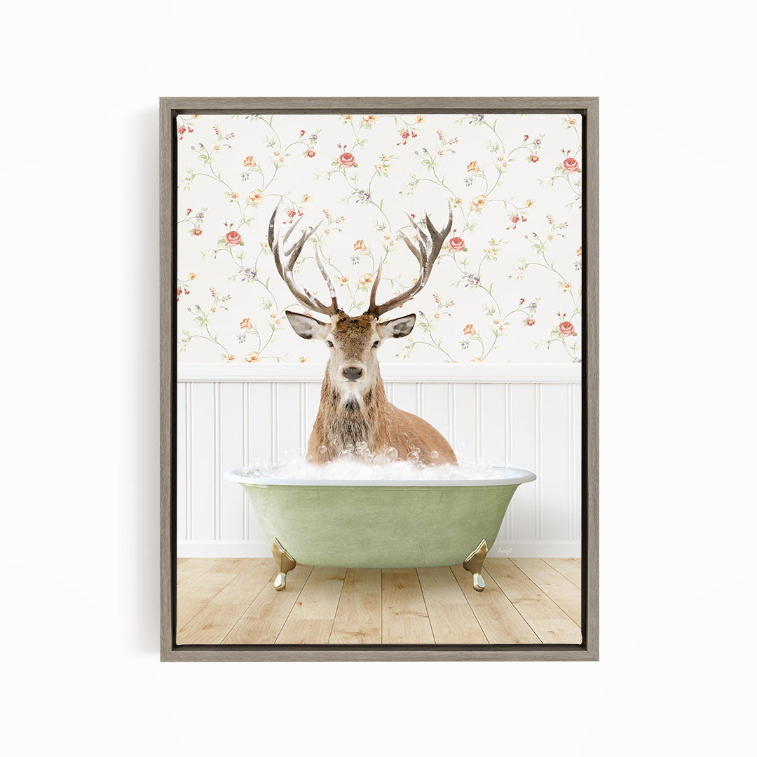 A deer with large antlers is sitting in a green bathtub, surrounded by a floral wallpaper.