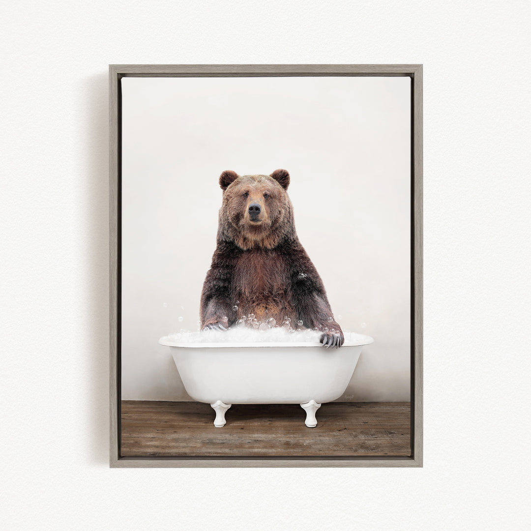 A brown bear sitting in a white bathtub filled with bubbles, appearing to enjoy the bath.