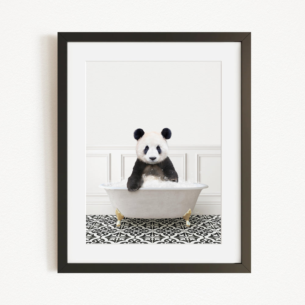 A panda bear sitting in a white bathtub with a black and white patterned rug on the floor.