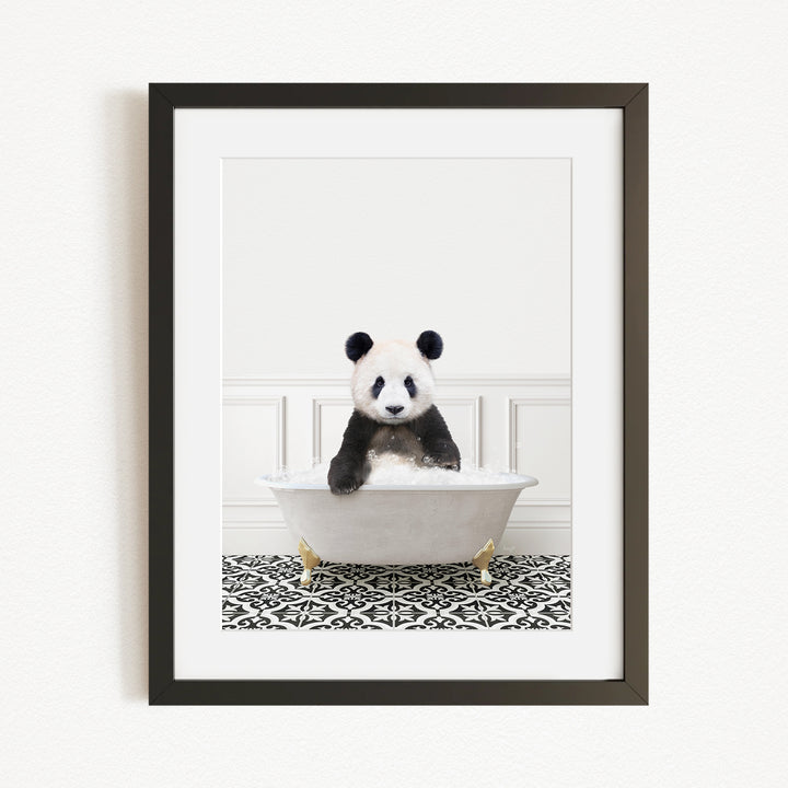 A panda bear sitting in a white bathtub with a black and white patterned rug on the floor.