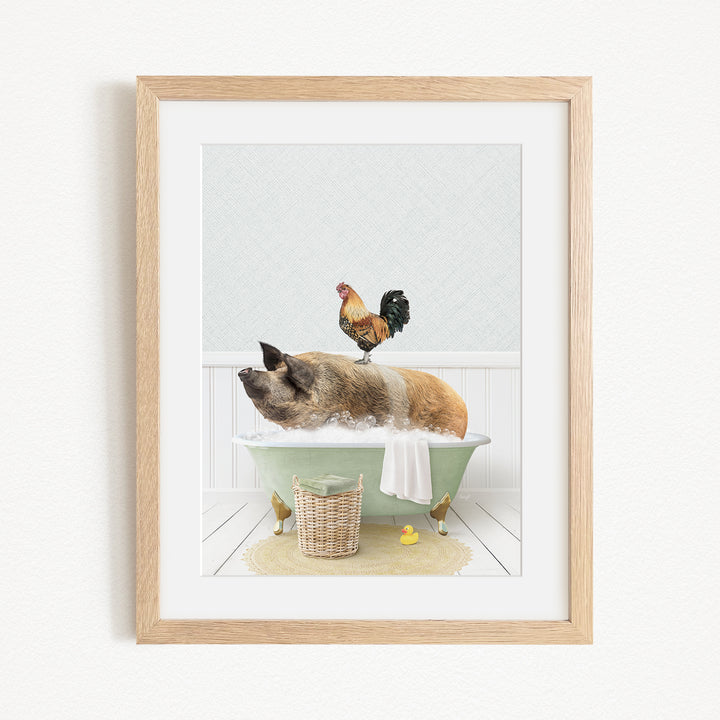 A framed image depicting a pig sitting in a bathtub, with a rooster perched on its back, and a basket of rubber ducks nearby.