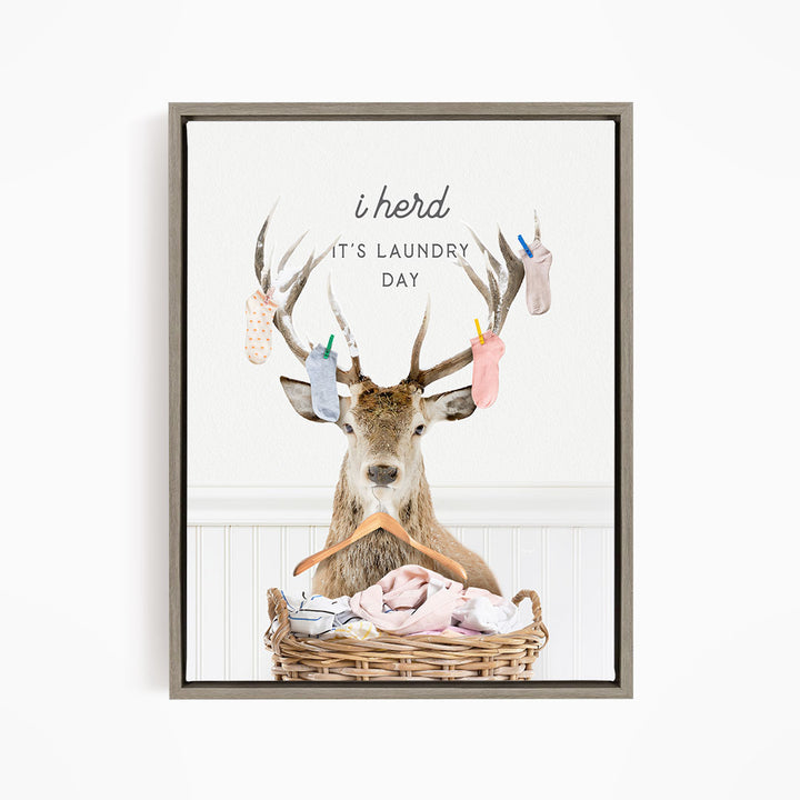 A deer with antlers is sitting in a basket filled with laundry, with socks hanging from its antlers.