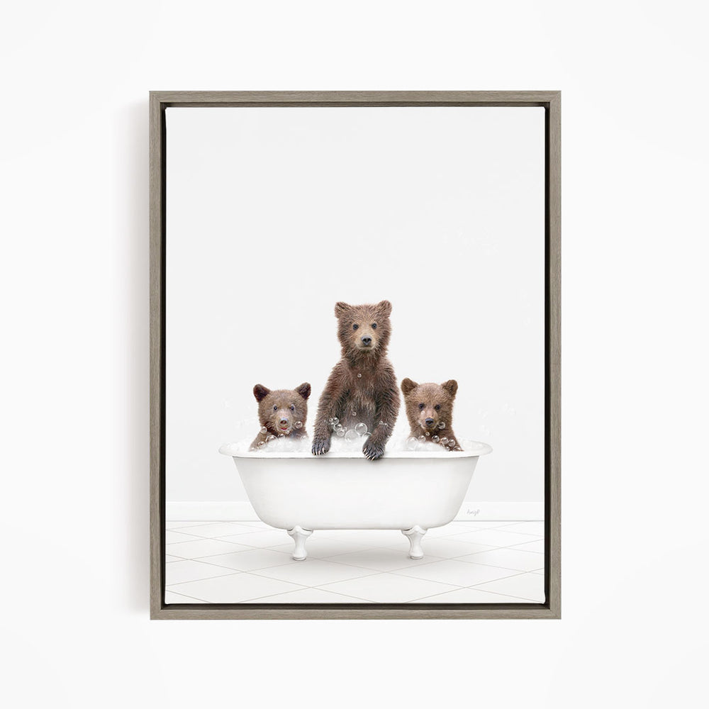 A framed image depicting three brown bears sitting in a white bathtub, with one bear sitting at the center and the other two bears sitting on either side.