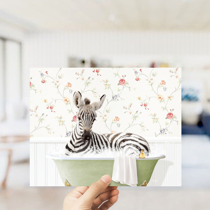A zebra is sitting in a green bathtub, surrounded by a floral pattern on the wall behind it.