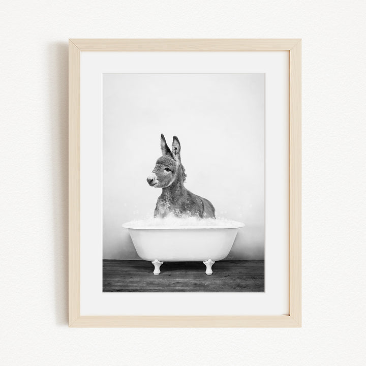 A donkey is sitting in a bathtub filled with water, creating a playful and whimsical scene.