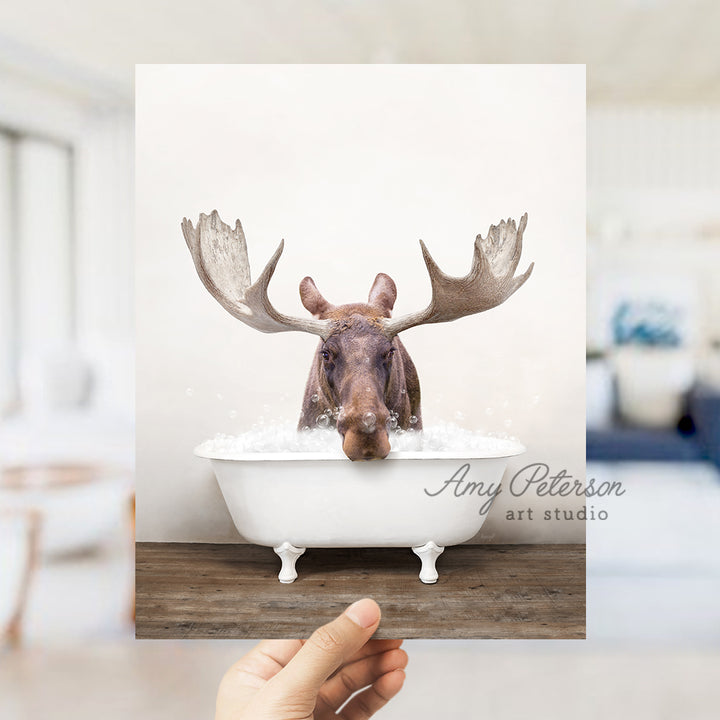 a person holding up a card with a picture of a moose in a bathtub