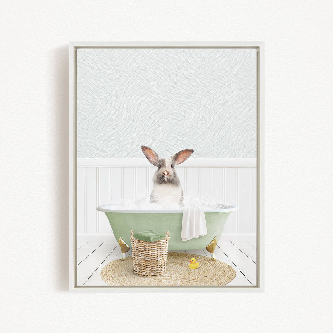 A fluffy gray and white rabbit sitting in a green bathtub filled with bubbles, surrounded by a yellow rubber duck and a woven basket.