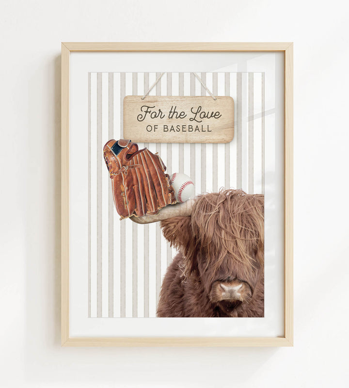 A framed image featuring a close-up of a brown cow's head with a baseball glove resting on its head, accompanied by a wooden sign that reads "For the Love of Baseball".